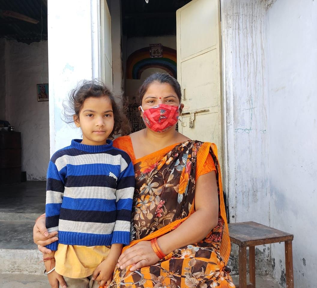 A caregiver and a young child from a Team100India partner community