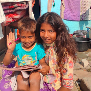 Two children reading together in their community